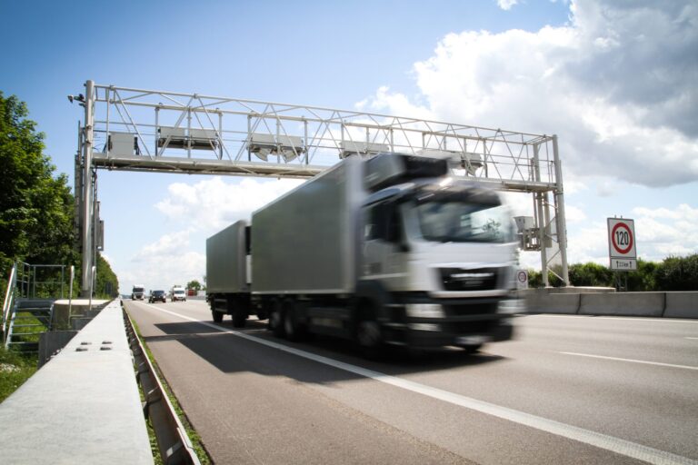 Truck passing under a roadside gantry used for WIM and freight traffic monitoring